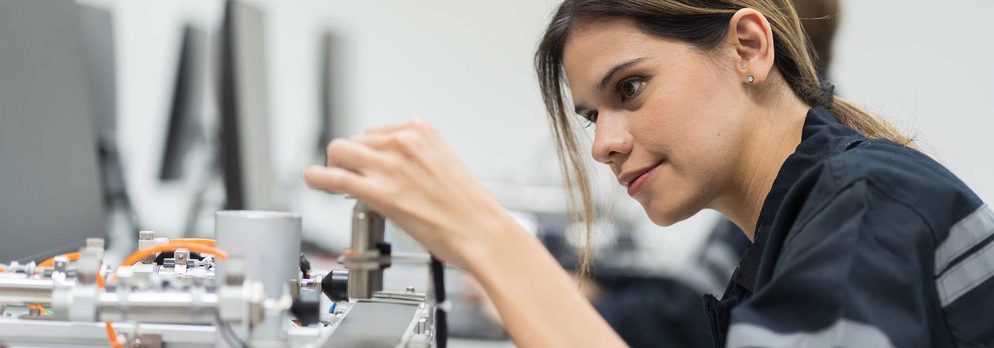 A young female is hands-on with an engineering programmable logic controller kit in the laboratory room