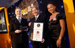 two female police officers being presented with an award 