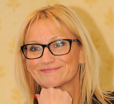 Woman with blonde hair and black rimmed glasses