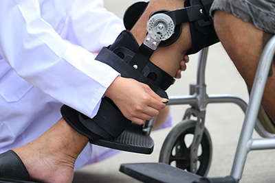 An  orthotists fitting a brace on someone's leg