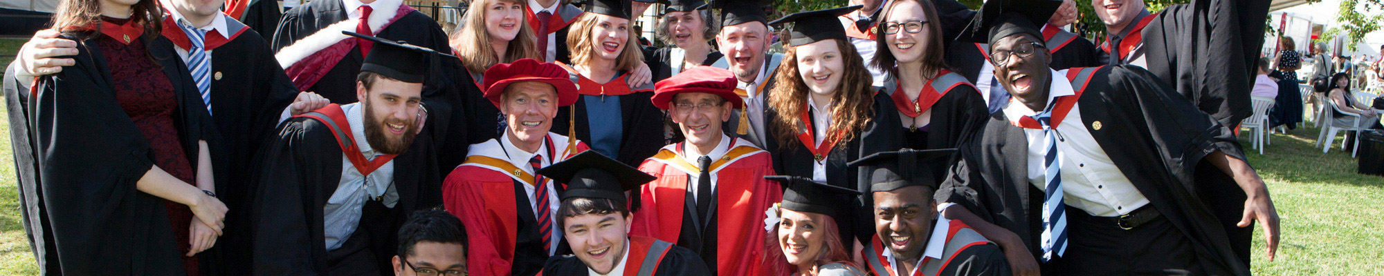 A group of alumni celebrating their graduation from Staffordshire University