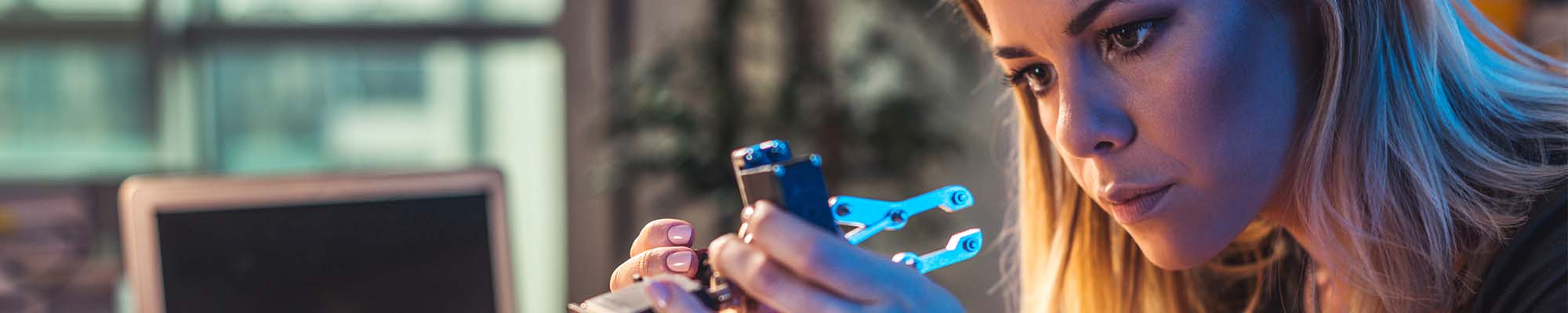 female graduate working on robotic arm