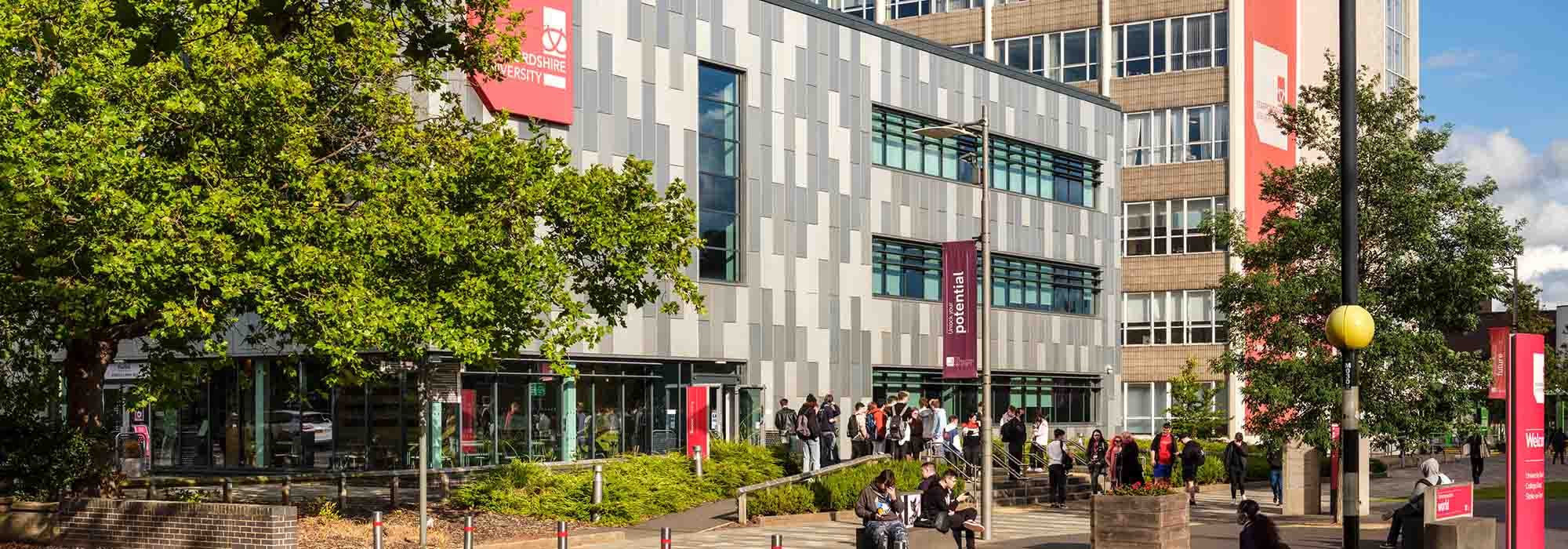 Staffordshire University's Beacon and Mellor buildings from the College Road view, surrounded by trees.