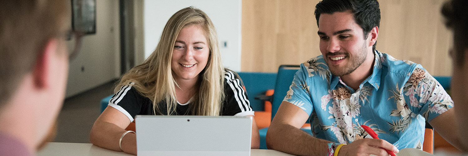 Postgraduate applicants reviewing their study options at a computer