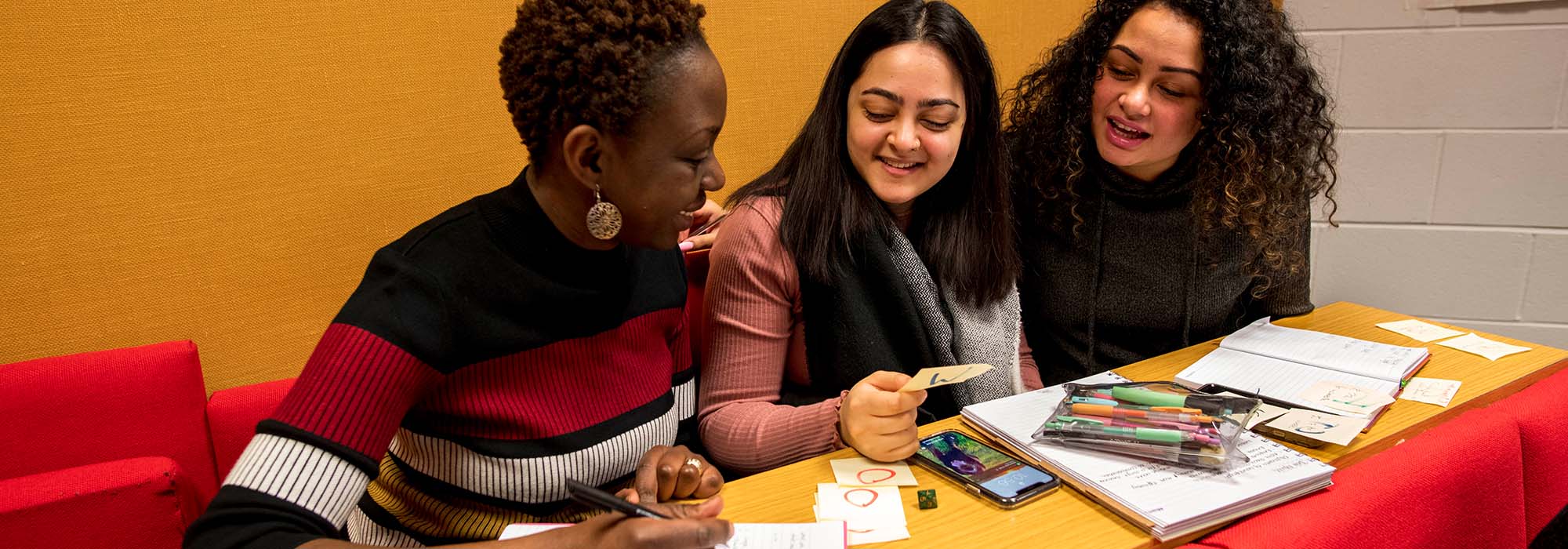 three female students working together in a lecture theatre