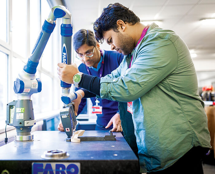 Student using a machine with lecturer