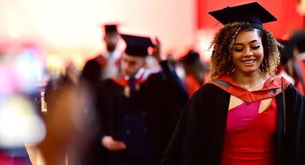 Female graduate wearing cap and gown at an award ceremony