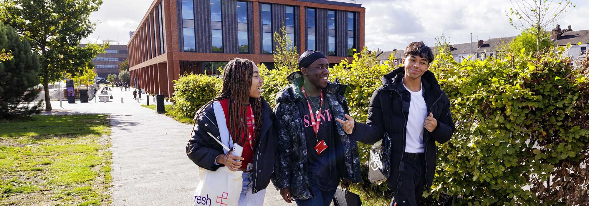 Three students walking in front of the Catalyst building.