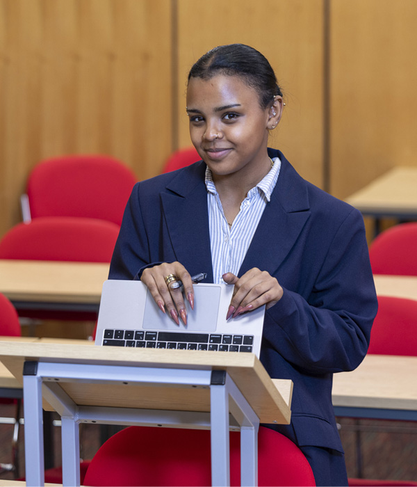 A female wearing a navy suit is smiling in the court mockroom