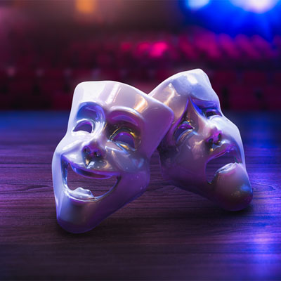 Drama and comedy masks on the floor on a theatre with ambient background lighting