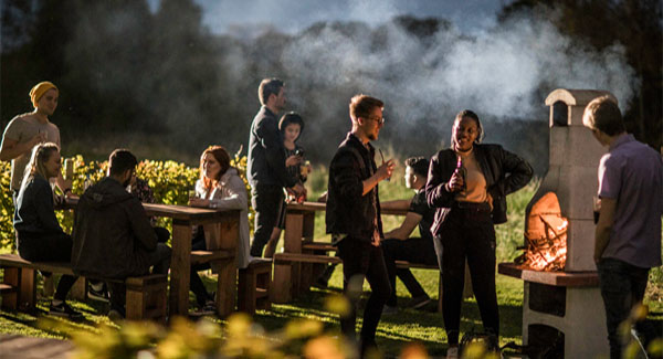 A group of students socialising at the communal garden area at Leek Road halls of residence at night time