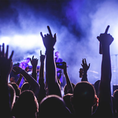 Live music concert with people standing in front of a band with ambient light effects