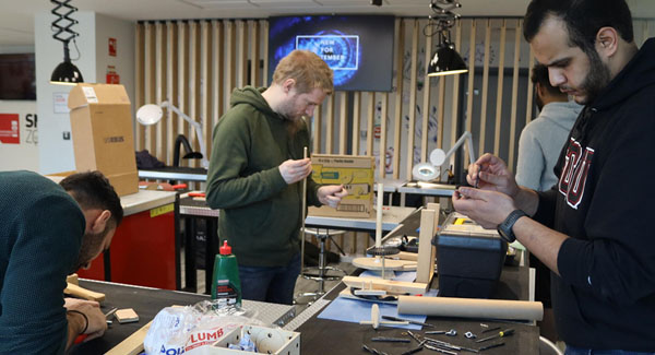 A group of male students crafting with materials and tools in the Smart Zone