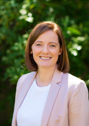 Portrait photograph of Helen wearing a pink blazer