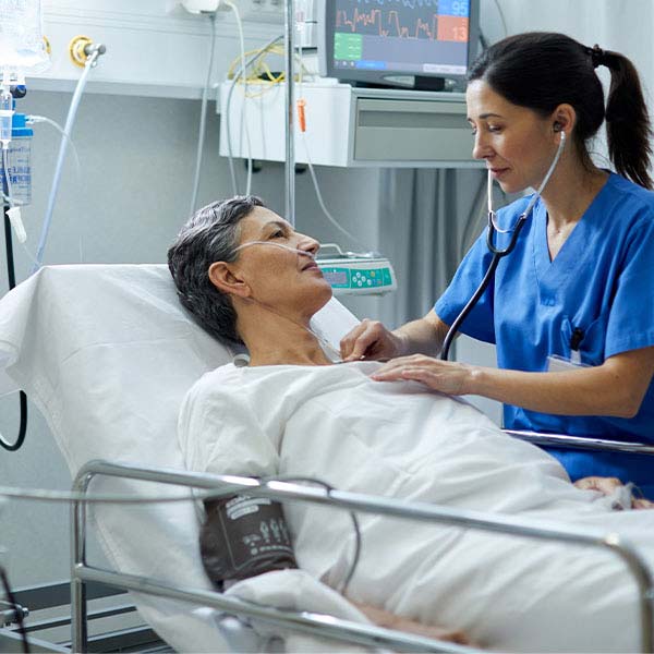 A nurse standing next to a patient in a hospital bed.
