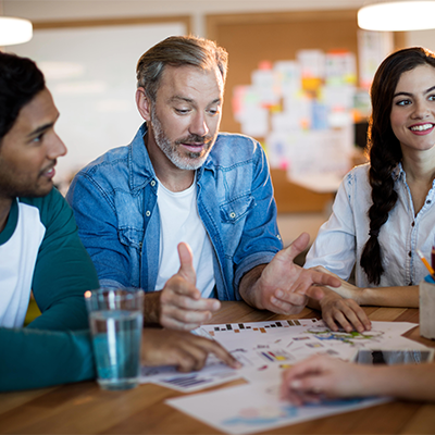 Three adults discussing plans in a meeting