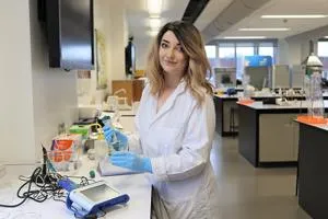 Student in a lab coat working on the project