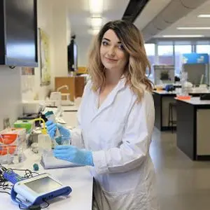 Student in a lab coat working on the project