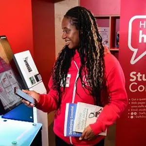 Female student holding books and mobile phone and looking at screen