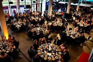 An overhead view of people sitting around round tables 
