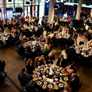 An overhead view of people sitting around round tables