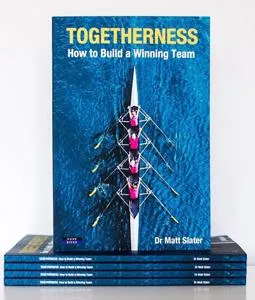 Blue book cover titled 'Togetherness: How to Build a Winning Team' displayed above a stack of copies.