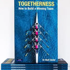 Blue book cover titled 'Togetherness: How to Build a Winning Team' displayed above a stack of copies.