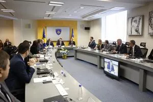 Officials sit around a U-shaped conference table during a formal cabinet meeting.