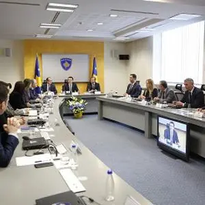 Officials sit around a U-shaped conference table during a formal cabinet meeting.