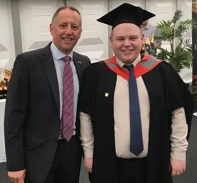 Employer and graduate apprentice posing for a photo at graduation