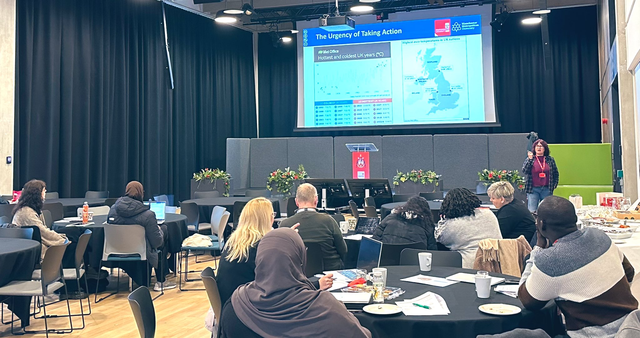 Delegates pictured at Staffordshire University's Carbon Literacy community day watching a presentation showcasing 'The Urgency of Taking Action'