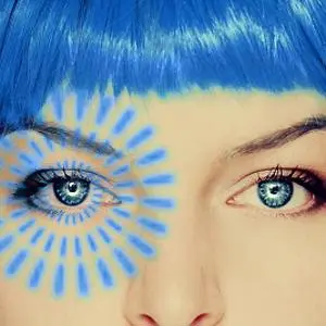 Close-up of a blue-haired woman with a blue and yellow sun design painted around one eye.