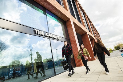 Three students walking outside The Catalyst building