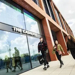 Three students walking outside The Catalyst building