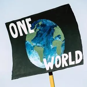 Handmade protest sign reading 'ONE WORLD' around a painted globe.