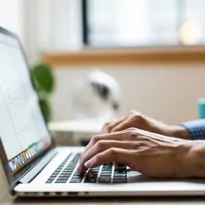 Someone's hands typing on a laptop computer