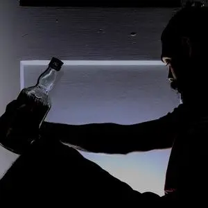 A man holding a bottle of alcohol