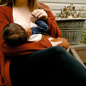 A parent breastfeeding their child