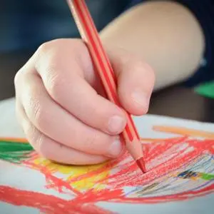 A child's hand doing a drawing