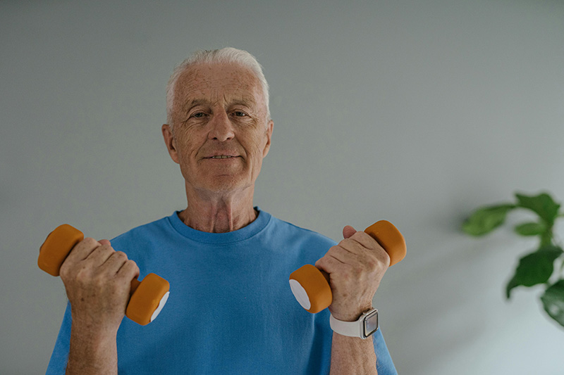 An older man holding some weights