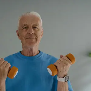 An older man holding some weights