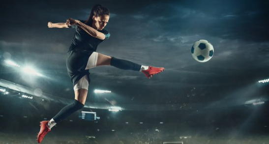 A woman kicking a football