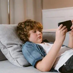 A young boy using a mobile phone