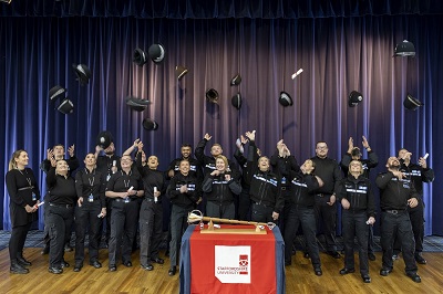 Graduates throw hats in the air in celebration