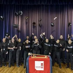 Graduates throw hats in the air in celebration