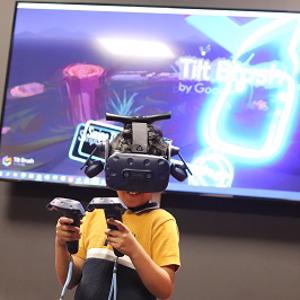 A boy wearing a VR headset and holding controllers