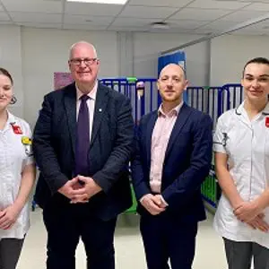 Four peoplestood in hospital ward setting