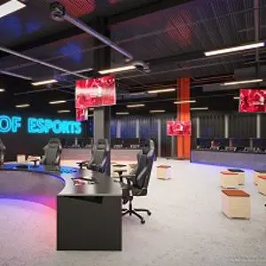 Empty gaming arena with rows of computers and a glowing sign reading 'HOME OF ESPORTS.'