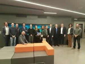 Project partners pose together in a modern room with orange seating.