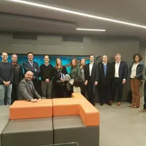 Project partners pose together in a modern room with orange seating.